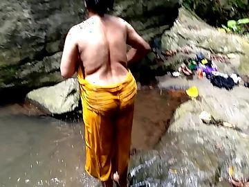 Ashok and Surwana Kumari take turns pissing adjacent to public while swill out adjacent to a pond adjacent to the woods